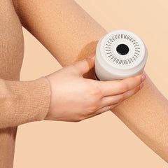 Lint Remover - A hand holds a white fabric shaver against a person's leg covered in tan fabric