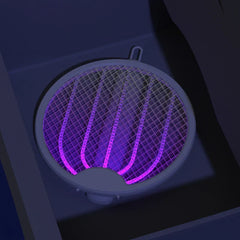Electric Fly Swatter - Close-up angled view of the same folded mosquito zapper glowing purple in a dark room corner.