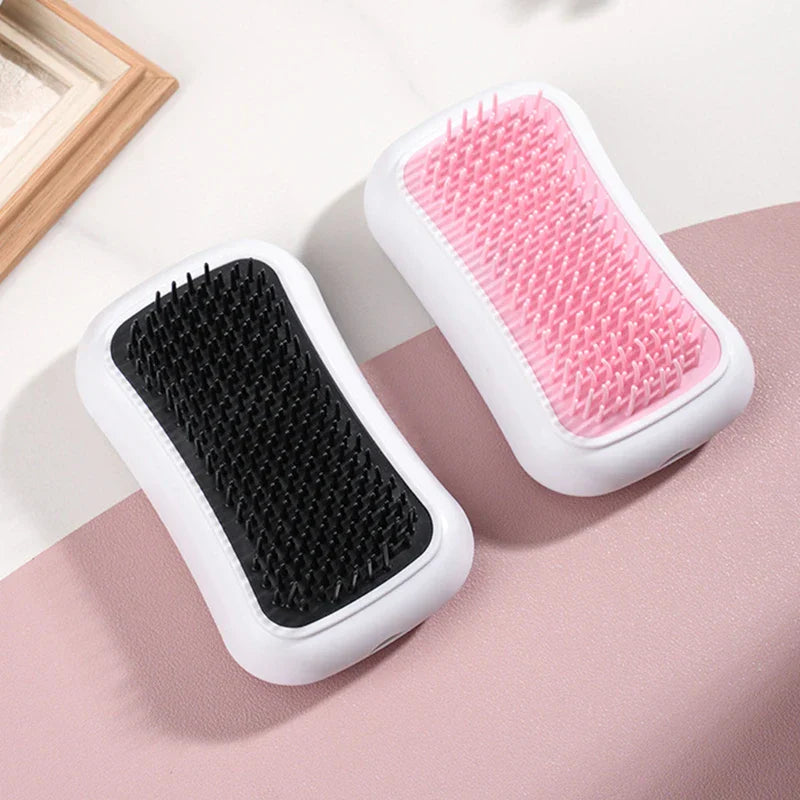 Outil de massage du cuir chevelu - Deux variantes de couleur de l’outil de massage manuel avec tampons roses et noirs, présentées sur une surface bicolore