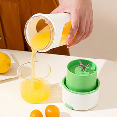 Juicer Extractor Machine - Hand pours yellow juice from a portable blender cup into a glass, with detached blender base and citrus fruits on a white table