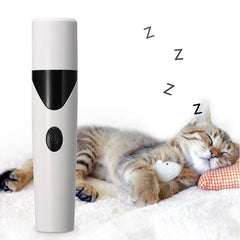 A capped electric pet nail grinder beside a sleeping tabby cat holding a small mouse toy.