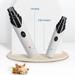 Two electric pet nail grinders displayed on a stand, with red charging and blue fully charged indicator lights, and a small kitten below.