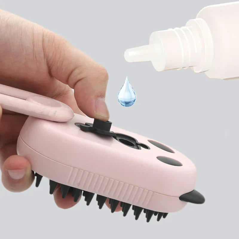 A hand opens the fill port of a pink electric spray handle massage brush, with a drop of liquid falling into it.