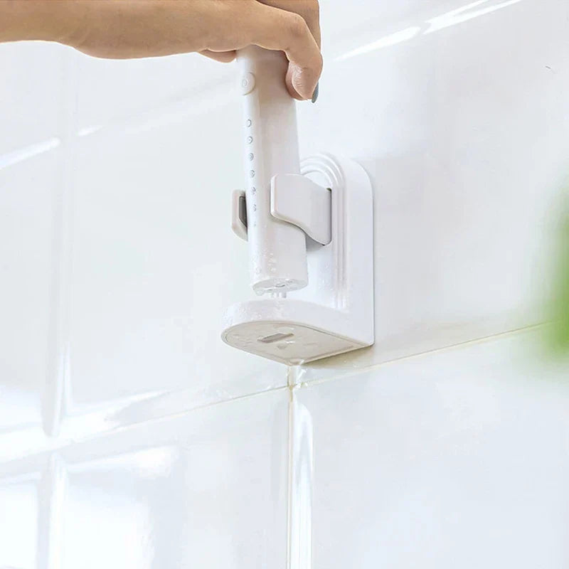 Soporte para cepillo de dientes eléctrico - Mano levantando un cepillo de dientes eléctrico de la unidad montada, mostrando ranuras de drenaje en la base