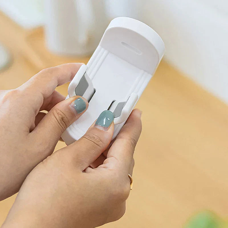 Soporte para cepillo de dientes eléctrico - Manos ajustando los dos clips de un soporte blanco montado en pared