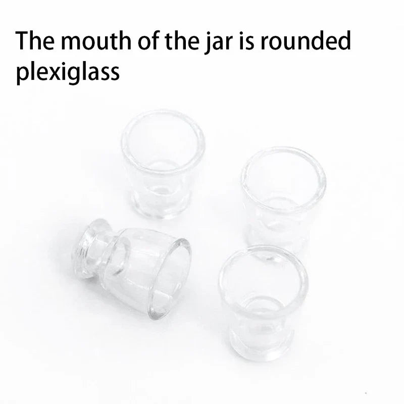 Vier kleine, klare, runde Plexiglas-Teile auf einer weißen Oberfläche.
