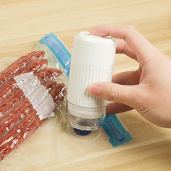 A hand holds a white handheld electric pump against a sealed food bag, demonstrating vacuum storage bags with electric pump in use