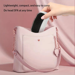 A hand places a white and black electric hair brush into a light pink handbag