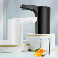 Water Jug Dispenser - White and black electric dispensing units displayed on tiered marble stands next to a glass of water and fresh orange slices