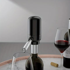 Wine Aerator Pourer - Black electric wine aerator and dispenser mounted on a wine bottle, dispensing red wine into a glass on a marble tray