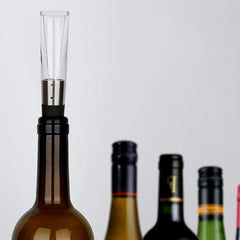 Electric Wine Aerator Pump - Aerator pourer inserted into the neck of an open wine bottle, with additional wine bottles blurred in the background
