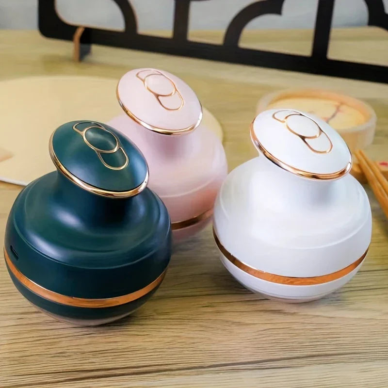Energy Pen - Three beauty devices in dark green, pink, and white with rose-gold accents placed on a wood-grain surface.