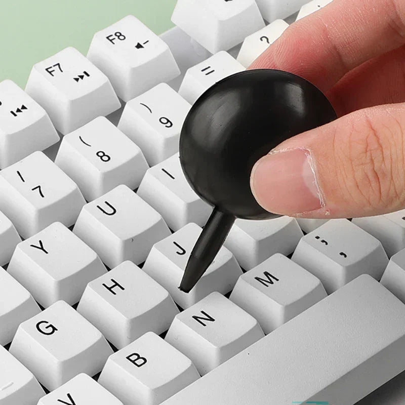 Electronics Cleaning Brush - Hand using the air blower tool to remove debris from between white keyboard keys