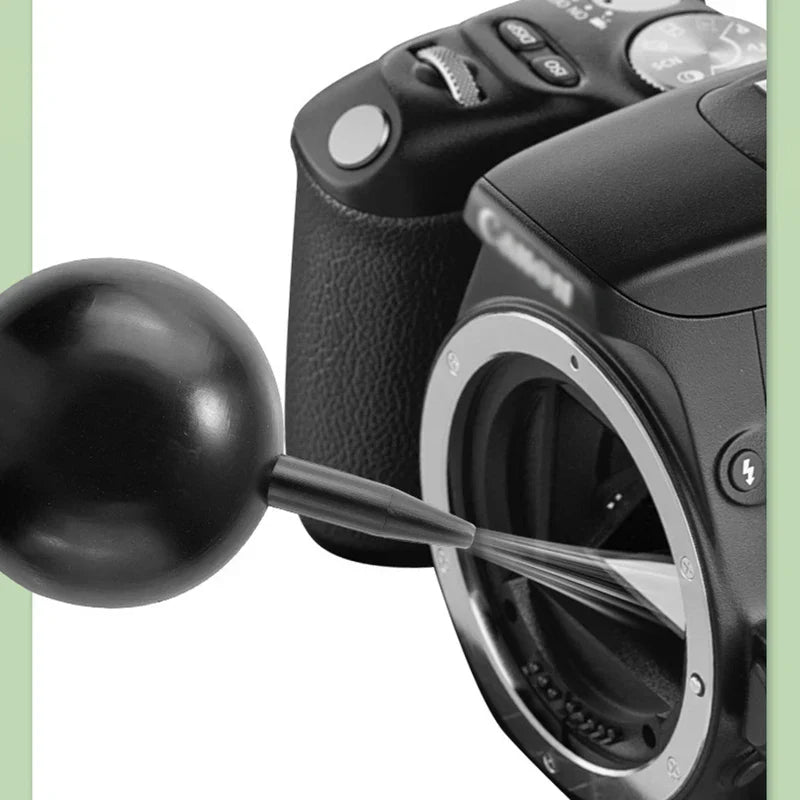 Electronics Cleaning Brush - Black rubber squeeze blower inserted into a Canon camera's open lens mount for sensor cleaning