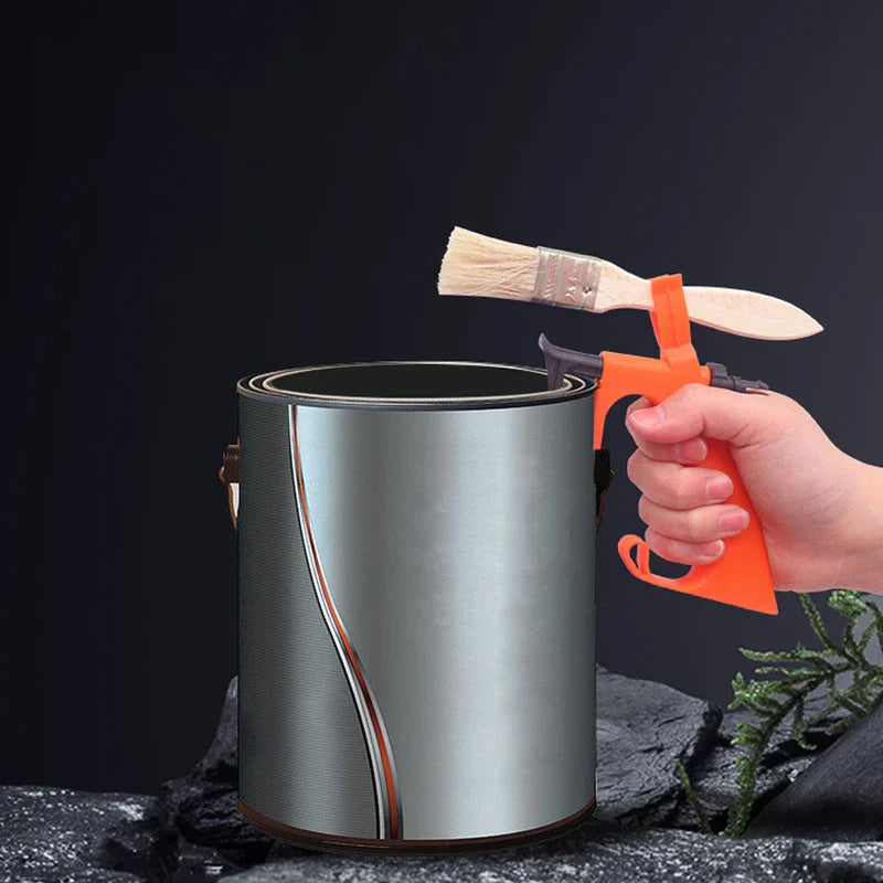 Soporte de agarre para bote de pintura: mano sosteniendo la herramienta sujeta a un bote de pintura metálico, con una brocha apoyada sobre la herramienta