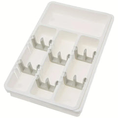 Cutlery Drawer - Three-quarter angled view of a small white plastic cutlery organizer tray with divided compartments and clip holders