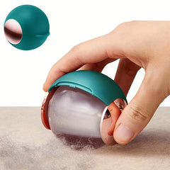 Sticky Lint Roller - Teal reusable lint remover being held to pick up pet hair from a fabric surface, with closed teal unit shown in upper left