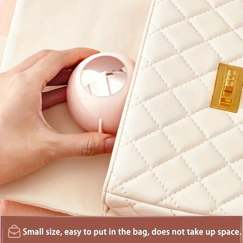 Sticky Lint Roller - Hand tucks a small round pink object into a quilted handbag pocket, text notes small bag-friendly size