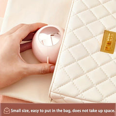 Sticky Lint Roller - Hand tucks a small round pink object into a quilted handbag pocket, text notes small bag-friendly size