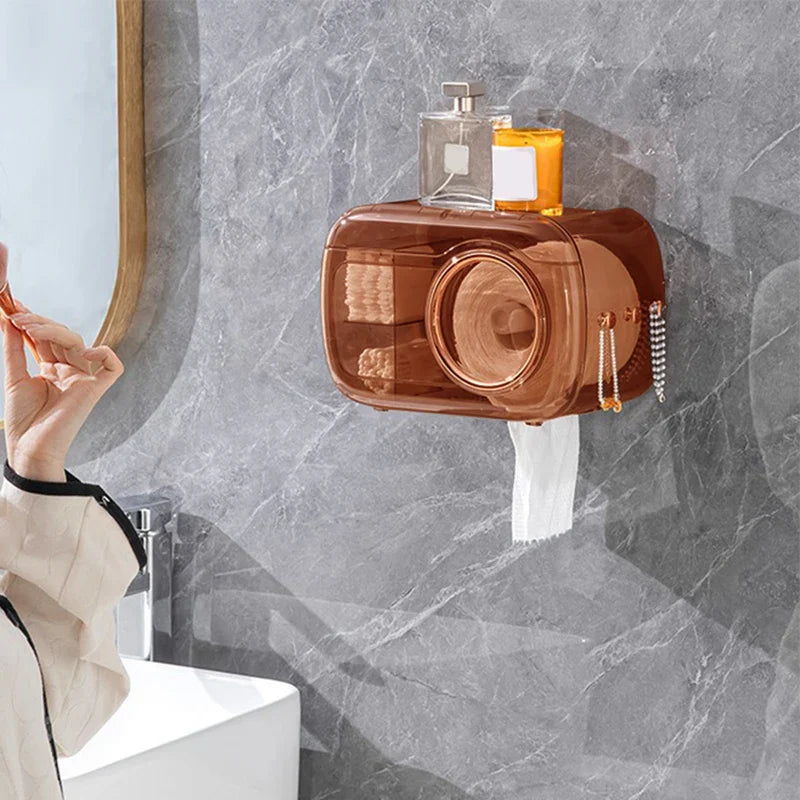Cotton Pad Dispenser Holder - Unit installed on a gray marble bathroom wall, holding a rolled face towel and stacked cotton pads, with a towel dispensing from the bottom slot and skincare items placed on the top shelf