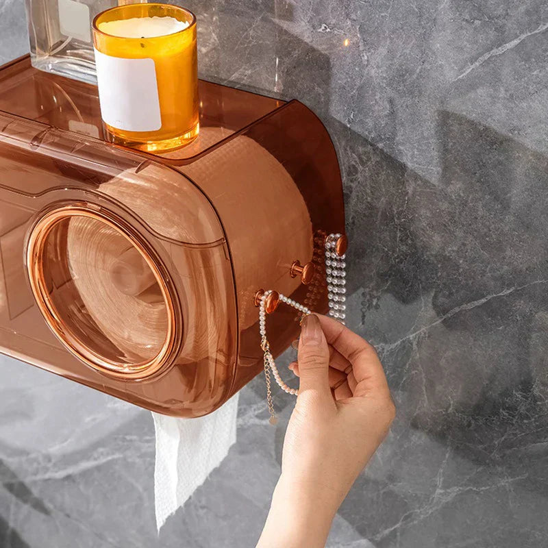 Cotton Pad Dispenser Holder - Close-up of the unit's side hooks with hanging beaded chains, a hand adjusting one chain, with a candle resting on the top shelf and a towel hanging from the bottom slot