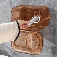Cotton Pad Dispenser Holder - Hand installing a white plastic roll holder rod into an amber-tinted open wall-mounted case, mounted on a gray marble-patterned surface.
