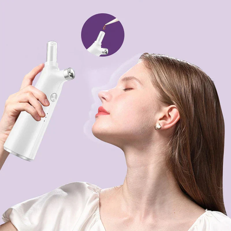 Nano Mist Sprayer - Hand holding the white spray device, directing mist toward a woman’s face against a light purple background, with a close-up inset of liquid being dropped into the device's top opening.