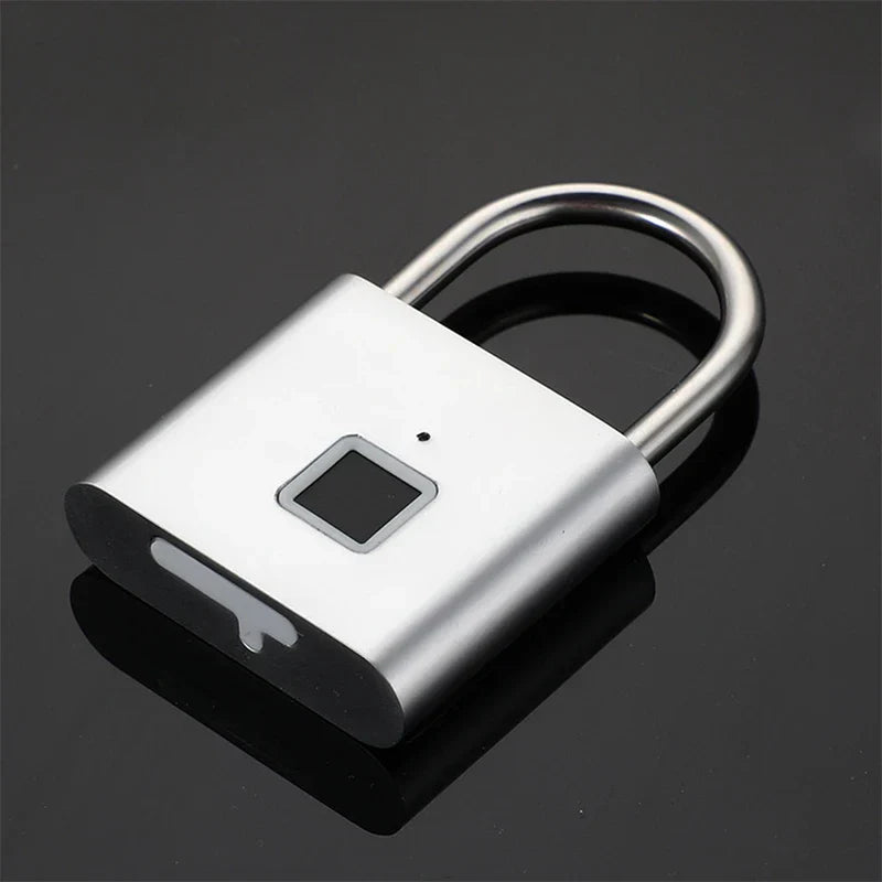 Keyless - Silver fingerprint padlock resting on a dark reflective surface, angled view