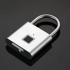 Keyless - Silver fingerprint padlock resting on a dark reflective surface, angled view
