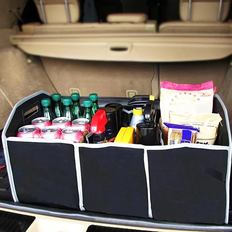 Foldable Car Trunk Organizer - Black fabric multi-compartment organizer sitting in a beige car trunk, holding drink bottles, cans, snacks and small containers.