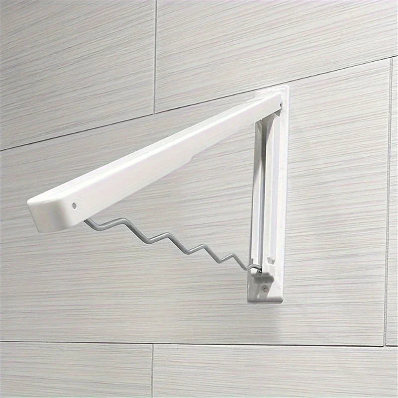 perchero retráctil para secar ropa - Brazo de secado plegable de pared en color blanco instalado en una pared de azulejos con acabado de madera gris claro, en posición extendida