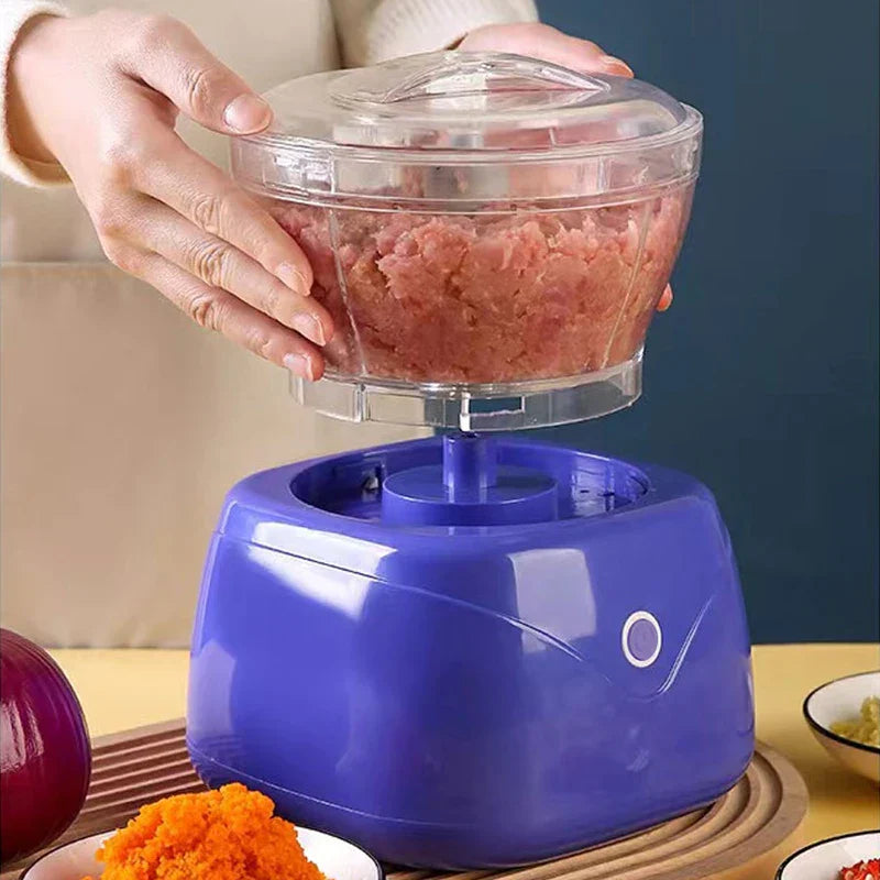 Food Grinding Sausage Stuffing Tool - Two hands lifting the transparent bowl of a purple electric food chopper, showing minced pink meat inside the bowl