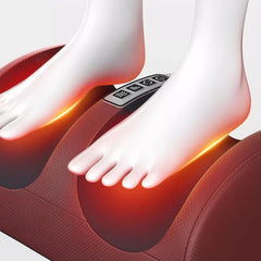 máquina masajeadora de pies - Dos pies descalzos descansando sobre un masajeador de piernas rojo, con brillo de calor naranja bajo los pies y botones de control superiores visibles