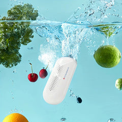 Fruit Vegetable Washing Machine - Capsule purifier submerged in bubbling water surrounded by cherries, kale, a lime, and an orange, demonstrating active cleaning action