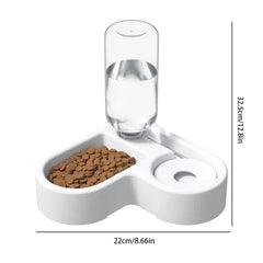comedero de agua por gravedad - Comedero para mascotas dos en uno blanco con cuenco de comida lleno de croquetas, botella de agua transparente acoplada y medidas de altura/longitud marcadas