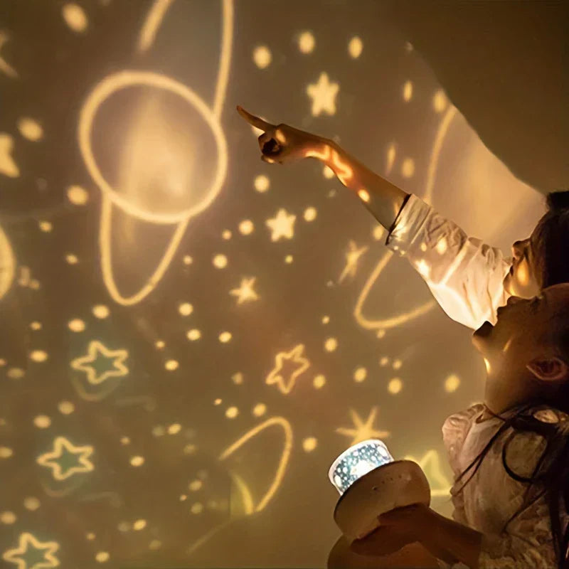 Star Projector Night Light - Child pointing at projected celestial stars and planets on a wall while holding the lit projector