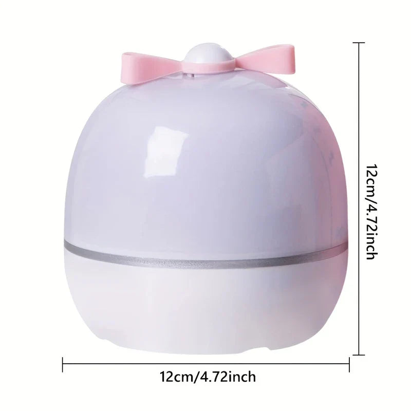Star Projector Night Light - Small rounded projector night light with pink top bow, light lavender and white two-tone body, 12cm dimension marks against white background