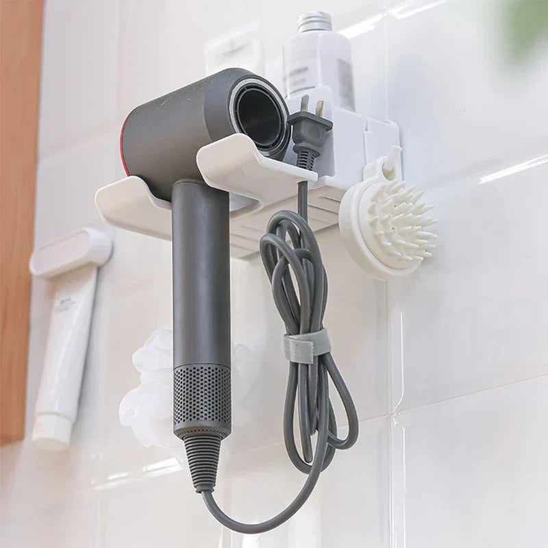 Hair Dryer Organizer - White wall-mounted hair dryer holder holding a gray hairdryer, coiled cord, and attached small brush on a tiled wall