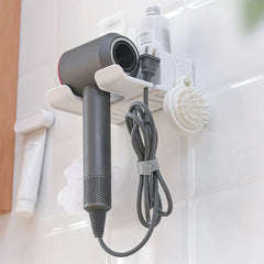 Hair Dryer Organizer - White wall-mounted hair dryer holder holding a gray hairdryer, coiled cord, and attached small brush on a tiled wall