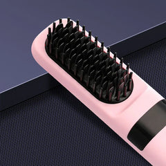 Hair Straightener Brush - Close-up partial angled view of a pink heated hair straightening brush resting on a dark perforated surface