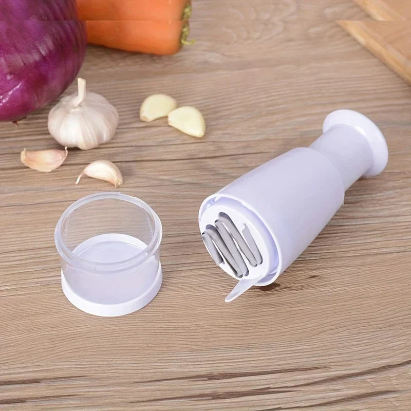 Food Chopper Mixer - Disassembled chopper showing blade assembly and clear collection cup, placed near fresh garlic, onion, and carrot