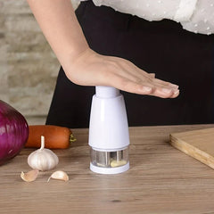 Food Chopper Mixer - Hand pressing down on the chopper top to process garlic cloves inside the clear chamber