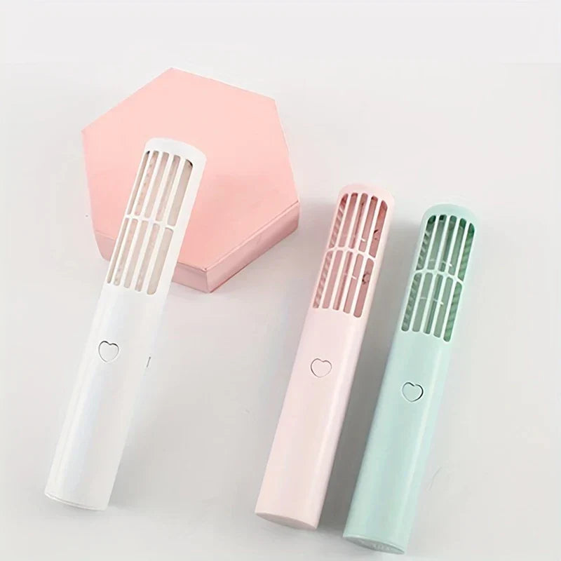 ventilador mini - Tres ventiladores de torre de mano en blanco, rosa claro y menta claro, mostrados sin soportes junto a un bloque hexagonal rosa