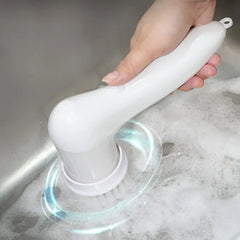 Electric Spin Scrubber - Person holding the handheld cleaning tool with bristle attachment, scrubbing a soapy stainless steel sink with rotating motion indicated by light effects