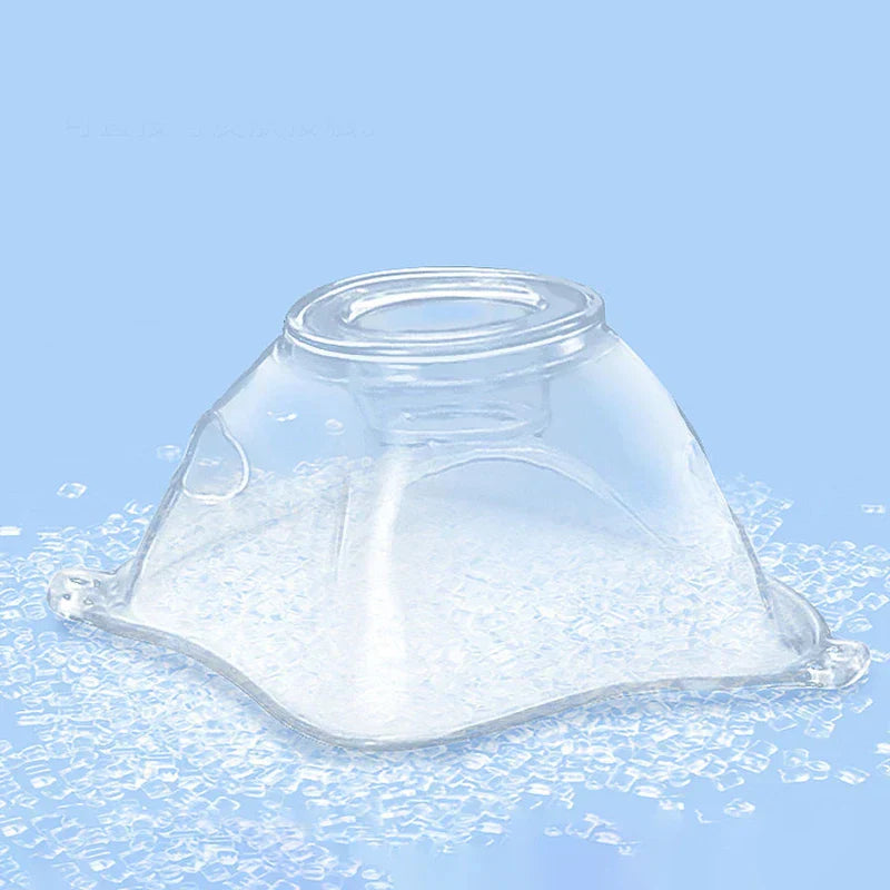 Clear plastic atomizer mask resting on small clear beads against a light blue background.
