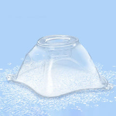 Clear plastic atomizer mask resting on small clear beads against a light blue background.