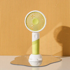 Mini Fan - White and lime green handheld fan placed on an irregular mirror base, with a white stand base.