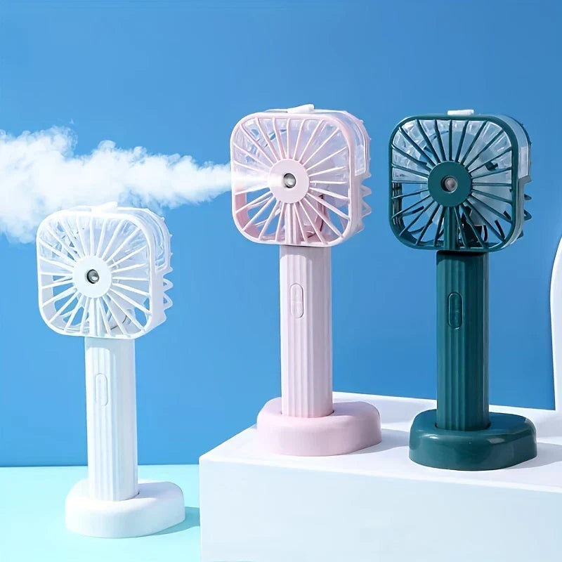 Mist Sprayer - Three color variants (white, pink, dark green) emitting visible fine mist against a bright blue sky background