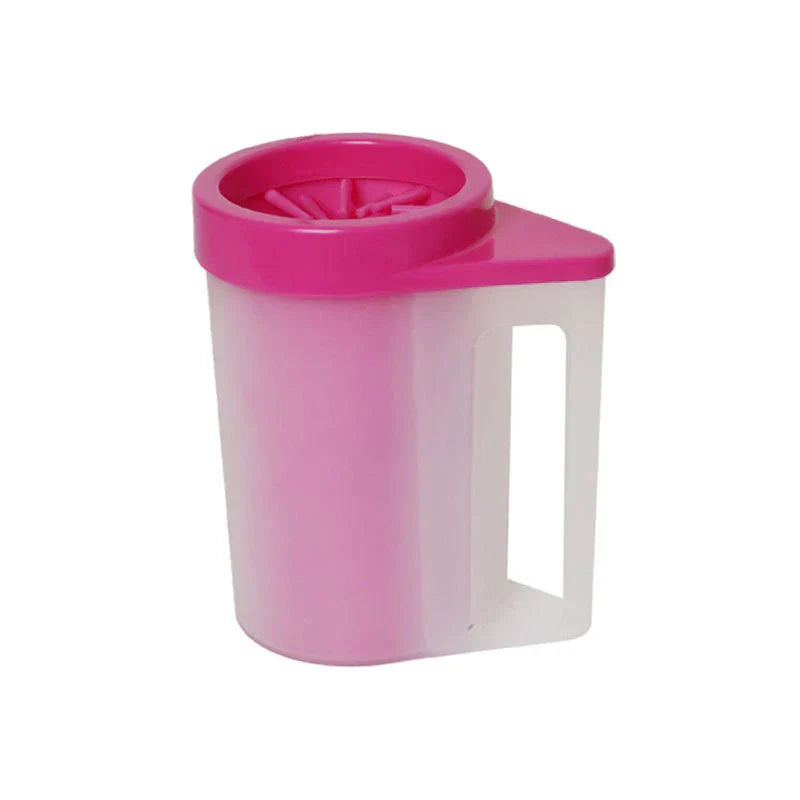 A pink and translucent pet paw washer with a handle, showing internal top scrubbing bristles