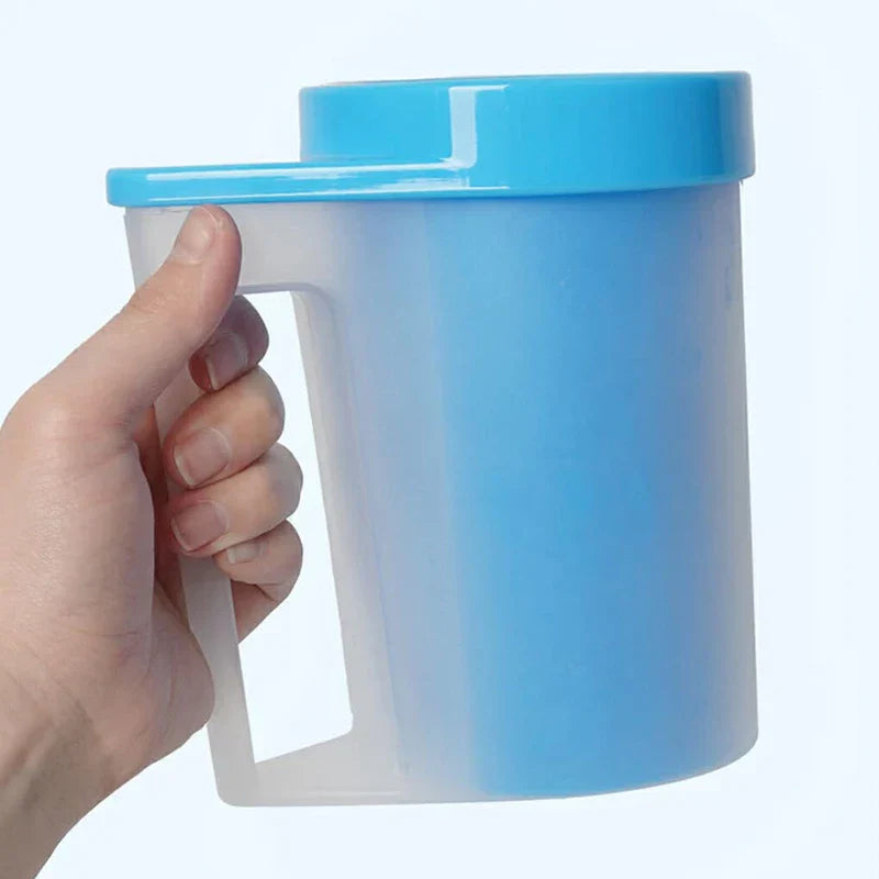 A hand holding the handle of a blue and translucent pet paw washer